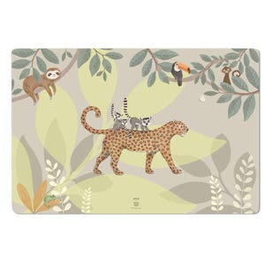 Puede incluir: Un mantel individual rectangular con una escena de la jungla. Un leopardo lleva lémures, con un perezoso, un tucán y un mono en los árboles. El fondo es de color beige claro con acentos de hojas verdes y amarillas. El mantel individual tiene el texto "ASHER + LITTLE LEO".
