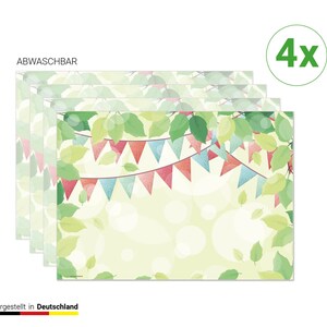 Könnte beinhalten: Vier Tischsets mit festlichem Design. Jedes Tischset hat einen hellgrünen Hintergrund mit einem Muster aus Blättern und einer Girlande aus bunten dreieckigen Flaggen. Der Text "ABWASCHBAR" ist oben links sichtbar.