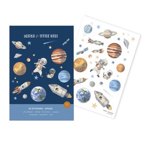 Könnte beinhalten: Zwei Stickerbögen mit Weltraum-Illustrationen. Einer ist marineblau mit Planeten, Raketen, Astronauten und dem Text "DESIGN for LITTLE ONES" und "35 STICKERS • SPACE". Der andere Bogen ist weiß mit ähnlichen Illustrationen.