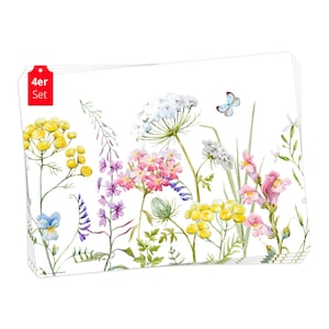 Puede incluir: Juego de cuatro manteles individuales blancos con un diseño de acuarela de flores silvestres y una mariposa. Los manteles individuales presentan una variedad de flores en tonos de rosa, morado, amarillo y blanco. El texto "4er Set" está impreso en la esquina superior izquierda de los manteles individuales.