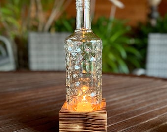 Single-flame table candlestick with an old Three Sixty Vodka bottle - glass on wood - special unique piece on squared wood - commissioned work