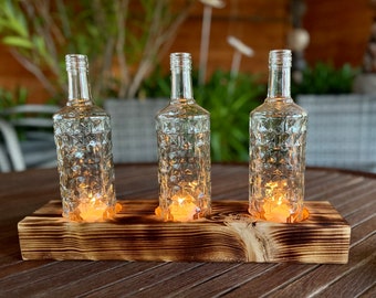 Three-flame table candlestick with old Three Sixty Vodka bottles - glass on wood - special unique piece on squared timber - commissioned work