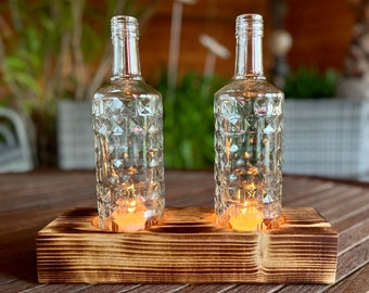 Two-flame table candlestick with old Three Sixty Vodka bottles - glass on wood - special unique piece on squared timber - commissioned work