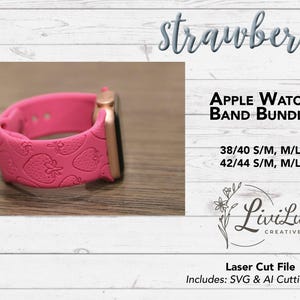 A hot pink Apple Watch band with a rose gold watch face, embossed with a strawberry pattern, rests on a light wood surface.