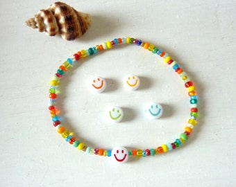 May include: A colorful beaded bracelet with smiley face charms. The bracelet is made with small, multi-colored beads and features four white smiley face charms.