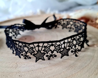 May include: Black lace choker with a star pattern and a black ribbon tie.
