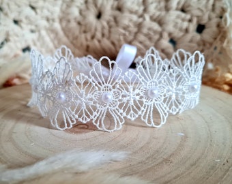 May include: White lace headband with pearl accents. The headband is delicate and feminine, perfect for a special occasion.