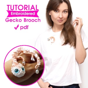 May include: An embroidered gecko brooch with a detailed design, featuring a beaded body and large blue eyes. The brooch is shown on a white t-shirt. The image also includes the text "TUTORIAL Embroidered Gecko Brooch pdf".