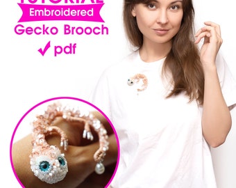 Può includere: Spilla a forma di geco ricamata con un design dettagliato, con corpo di perline e grandi occhi blu. La spilla è mostrata su una maglietta bianca. L'immagine include anche il testo "TUTORIAL Embroidered Gecko Brooch pdf".