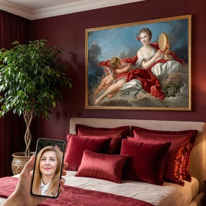 May include: A framed oil painting depicting a woman holding a tambourine with a winged cherub, set against a cloudy sky. The artwork features vibrant red drapery and soft white fabric, displayed in a room with deep red walls and velvet pillows.