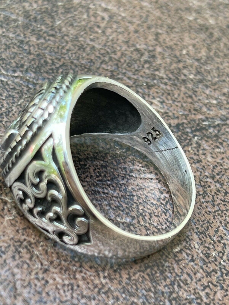 Puede incluir: Un anillo de plata con dise&ntilde;os intrincados y el n&uacute;mero "925" estampado en la banda interior.