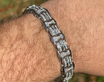 May include: A silver bracelet with a chain link design, featuring a row of baguette-shaped diamonds.