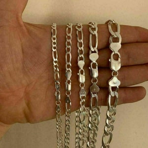 May include: Five silver chains of different widths and lengths. The chains are all made of a silver metal and have a shiny finish.