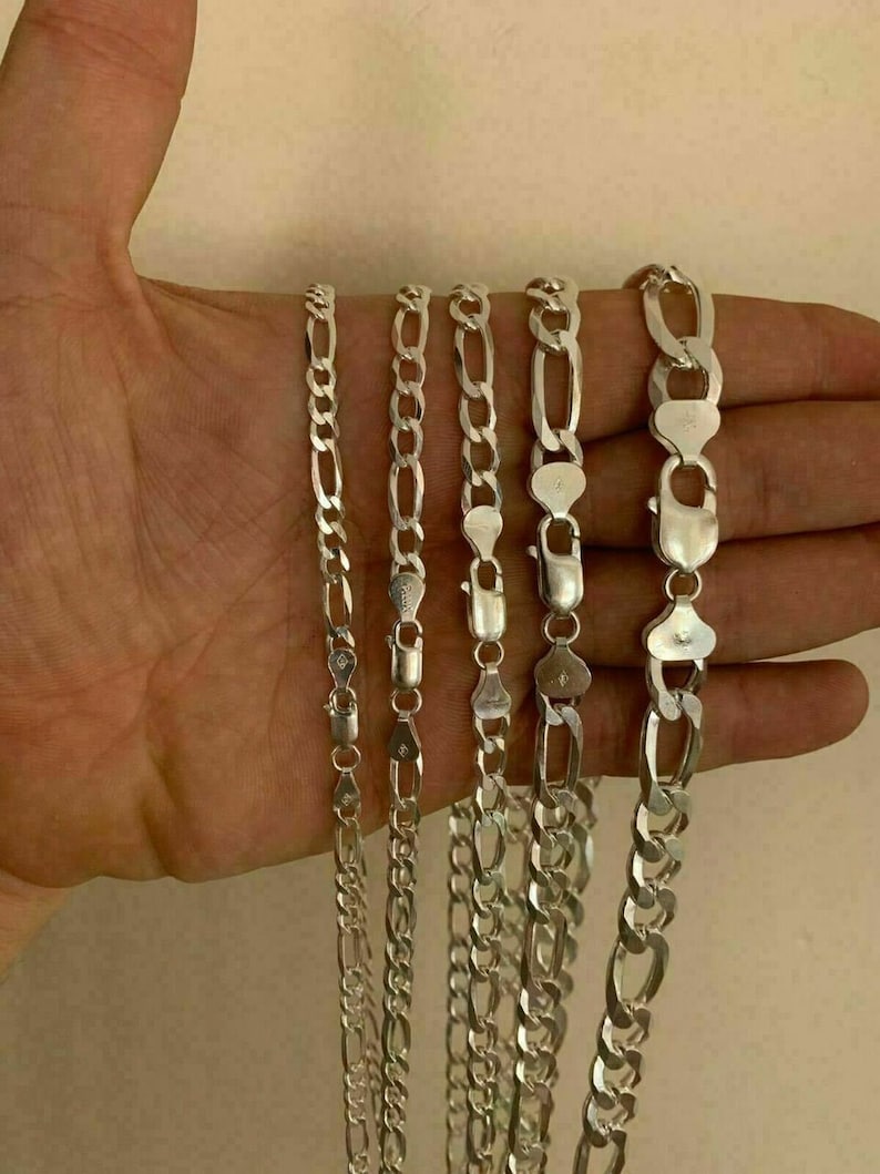 May include: Five silver chains of different widths and lengths. The chains are all made of a silver metal and have a shiny finish.