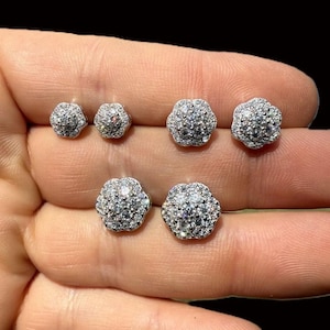 May include: Five pairs of silver flower-shaped stud earrings with clear cubic zirconia stones.