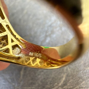 Puede incluir: Primer plano del interior de un anillo de oro con la inscripci&oacute;n "M 925" en la banda.