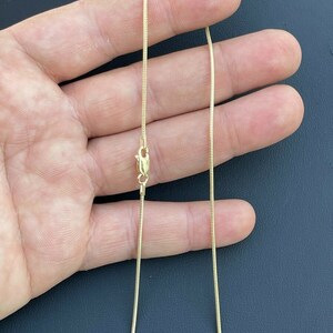 Puede incluir: Un collar de cadena de serpiente de oro con cierre de langosta.