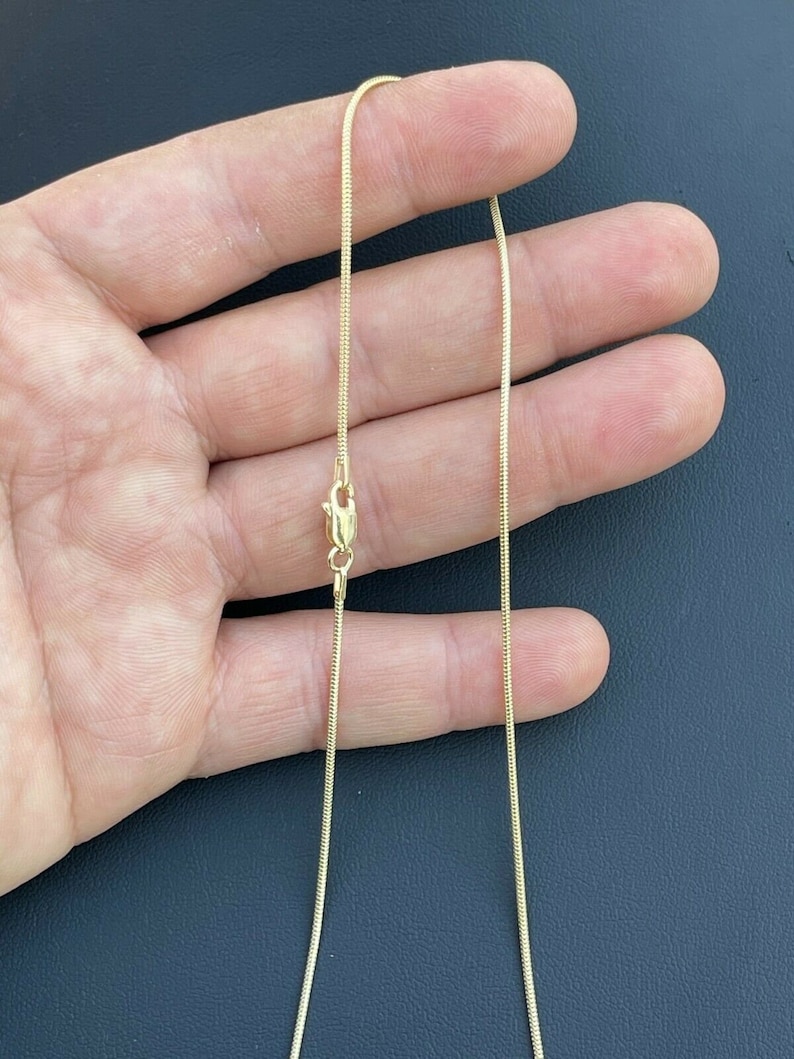 Puede incluir: Un collar de cadena de serpiente de oro con cierre de langosta.