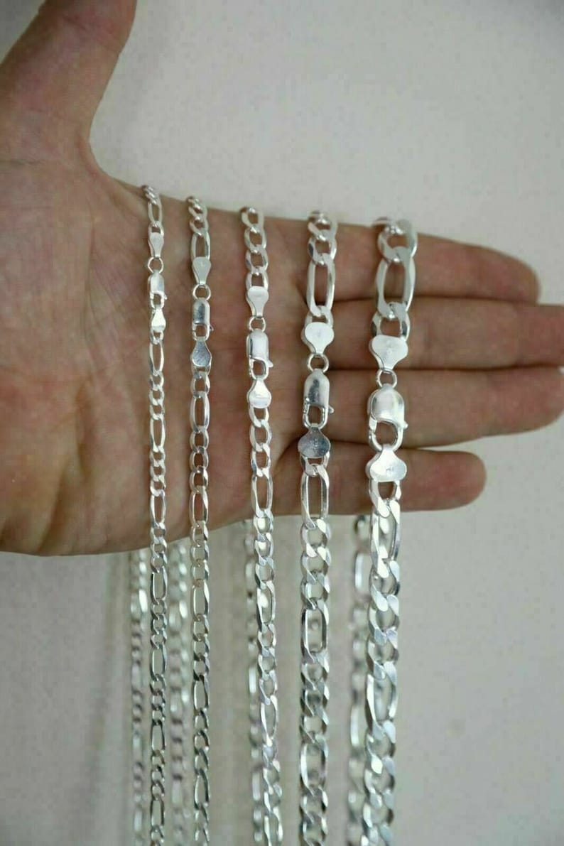 May include: Five silver chains of different lengths and widths. The chains are all made of a silver metal and have a shiny finish.