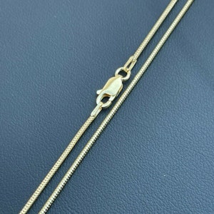 Puede incluir: Un collar de cadena de oro con cierre de langosta. La cadena es de estilo serpiente.