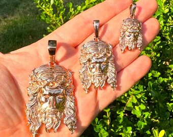 May include: Three gold-toned Jesus pendants of varying sizes. The pendants feature a detailed depiction of Jesus's face with a crown of thorns.