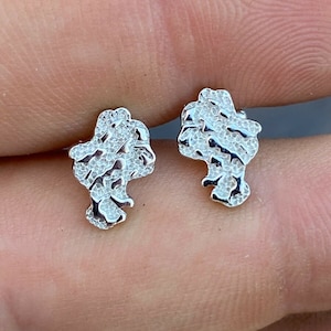 May include: A pair of silver earrings with a textured, nugget-like design.