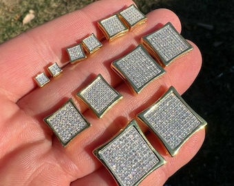 May include: A set of nine gold square-shaped earrings with diamond accents. The earrings are arranged in size order from smallest to largest.