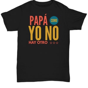 May include: Black t-shirt featuring the Spanish phrase "PAPÁ COMO YO NO HAY OTRO" in orange and yellow. The text includes the word "COMO" in a blue circle. Three orange stars are positioned below the text.
