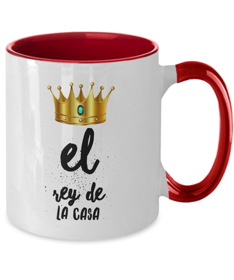 Puede incluir: Taza de cer&aacute;mica blanca con interior y asa rojos. La taza presenta un dise&ntilde;o de corona dorada con una gema verde y el texto "el rey de LA CASA" en escritura negra. Una divertida idea para regalo.