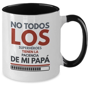 Könnte beinhalten: Weißer Keramikbecher mit schwarzem Innenraum und Henkel. Der Becher trägt den Text "NO TODOS LOS SUPERHÉROES TIENEN LA PACIENCIA DE MI PAPÁ" in grauen und roten Buchstaben. Eine schwarz-weiße Ladebalken-Grafik befindet sich darunter.