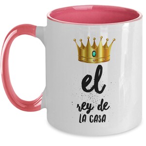 Puede incluir: Taza de cer&aacute;mica blanca con interior y asa rosas. La taza presenta una corona dorada y el texto "el rey de LA CASA" en escritura negra.