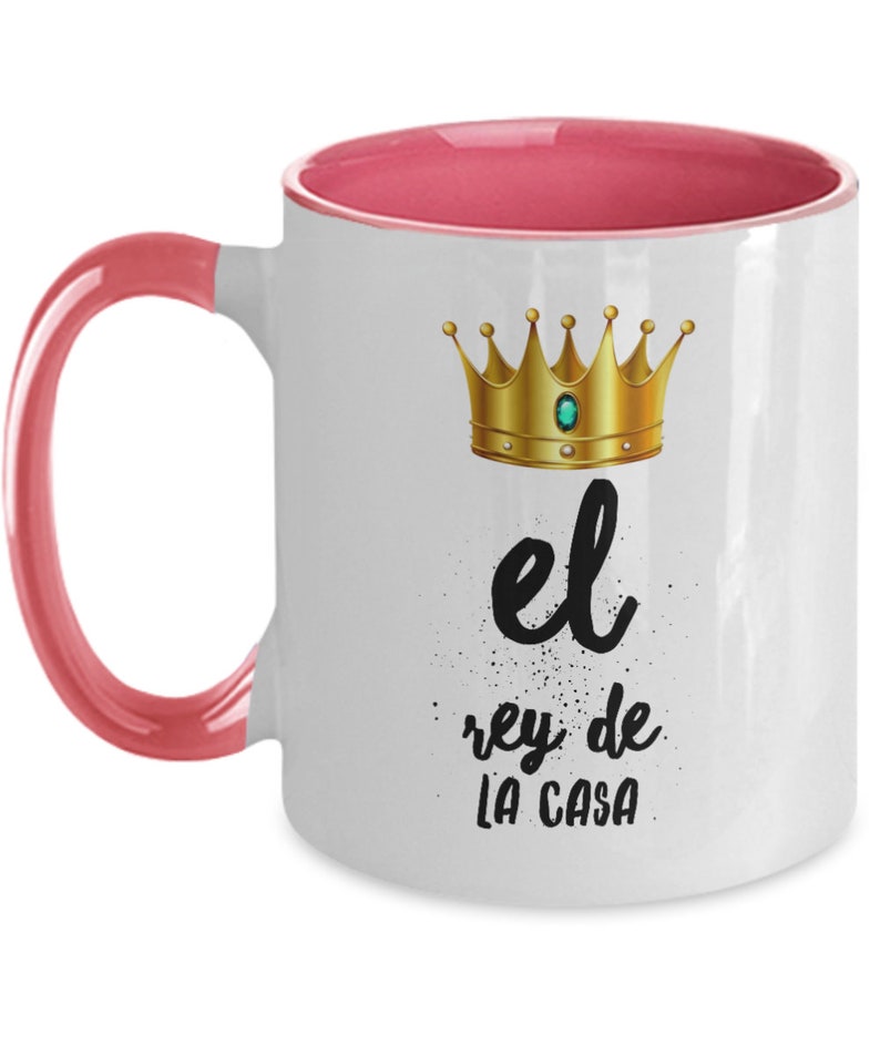 Puede incluir: Taza de cer&aacute;mica blanca con interior y asa rosas. La taza presenta una corona dorada y el texto "el rey de LA CASA" en escritura negra.