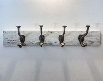 White coat rack made from a fruit crate with four metal double hooks