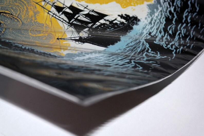 May include: A print showing a black sailing ship battling a storm at sea. The artwork features a yellow sky, dark waves, and a black ship with detailed rigging. The print is on a textured surface, with a white border.