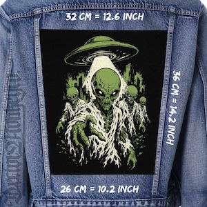 Può includere: Una giacca di jeans blu con una grande toppa rettangolare sul retro raffigurante alieni verdi e un UFO. La toppa misura 32 cm per 36 cm, ovvero 12,6 pollici per 14,2 pollici, con una larghezza inferiore di 26 cm o 10,2 pollici.