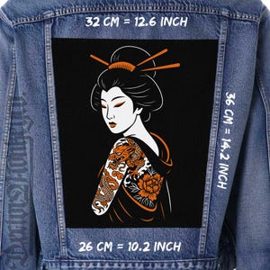 Pode incluir: Casaco de ganga com um grande patch preto com uma ilustração de gueixa. A gueixa tem uma tatuagem de dragão no braço e detalhes em laranja. O patch mede 32 cm de largura por 36 cm de altura.