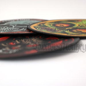 May include: A stack of four circular patches with various designs. The top patch features a green and yellow zombie skull. The bottom patch has a red and black wolf design. The text "Darius Monkeyco" is visible.