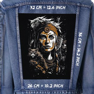 May include: A black and gold embroidered patch featuring a woman with a headdress and two wolves. The patch is 32 cm wide, 36 cm tall, and 26 cm deep.