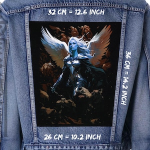 Puede incluir: Una chaqueta vaquera con un gran parche en la espalda que presenta un ángel de alas blancas con una espada. El ángel está rodeado de un fondo oscuro y arremolinado. El parche mide 32 cm de ancho, 36 cm de alto y 26 cm de profundidad.