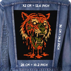 May include: A denim jacket with a large, rectangular patch featuring a stylized tiger head design. The tiger is depicted in orange, green, and yellow hues against a black background. The patch measures 36 cm high, 32 cm wide, and 26 cm long.