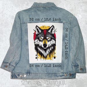 May include: Light blue denim jacket featuring a large graphic of a wolf with yellow eyes, a red sun, and yellow accents. The graphic measures 12.6 inches wide by 14.2 inches high. The jacket has a classic collar and button closure.