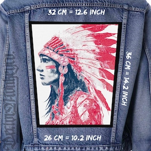 May include: A blue denim jacket featuring a large rectangular patch on the back. The patch displays a profile illustration of a person wearing a feathered headdress in shades of red and dark blue. Dimensions are 32 cm by 26 cm wide and 36 cm tall.
