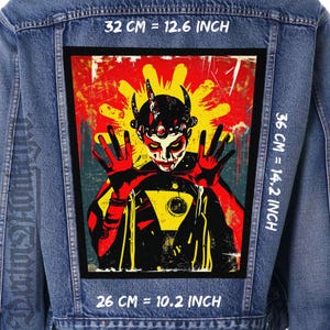 May include: A denim jacket with a large, rectangular patch featuring a stylized illustration. The artwork depicts a figure with horns, a red and yellow color scheme, and outstretched hands. The patch measures 12.6 inches wide, 14.2 inches high, and 10.2 inches long.