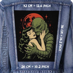 May include: A blue denim jacket featuring a large rectangular back patch with a graphic illustration of a green creature embracing a person under a red moon. The patch measures 12.6 inches by 14.2 inches, with a width of 10.2 inches at the base.