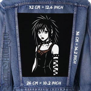 Może przedstawiać: Kurtka dżinsowa z dużą czarną naszywką z czarno-białą ilustracją gotyckiej postaci z anime. Naszywka ma 32 cm szerokości, 36 cm wysokości i 26 cm szerokości. Postać ma czarne włosy, obrożę i ciemny strój.
