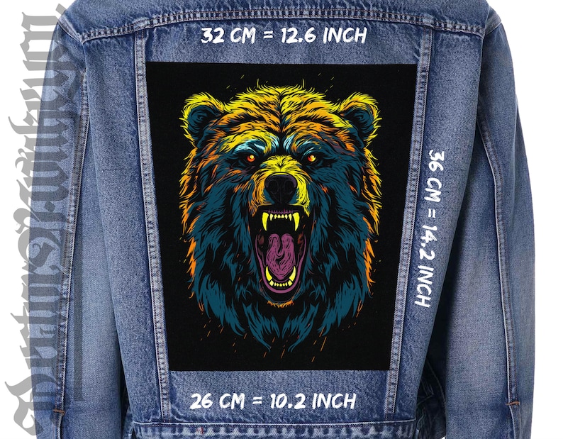 Peut inclure: Veste en jean avec un &eacute;cusson de grand ours color&eacute;. L'&eacute;cusson, mesurant 32 cm de large et 36 cm de haut, repr&eacute;sente un ours rugissant aux couleurs jaune, orange et bleu. La gueule de l'ours est ouverte.