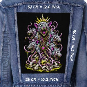 Pode incluir: Casaco de ganga com um grande patch preto com uma ilustração detalhada de vários ratos com coroas e correntes, rodeados por caveiras. O patch mede 32 cm de largura, 36 cm de altura e 26 cm de comprimento.