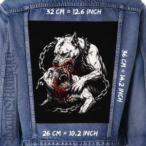 May include: A denim jacket with a large, rectangular patch featuring a detailed black and white illustration of two snarling dogs in a fight. The patch measures 12.6 inches by 14.2 inches and 10.2 inches. The jacket is blue.