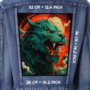 Pode incluir: Uma jaqueta de ganga com um remendo bordado de uma cabeça de lobo rosnando em verde e vermelho. O remendo tem 26 cm de largura, 36 cm de altura e 32 cm de altura de cima para baixo.