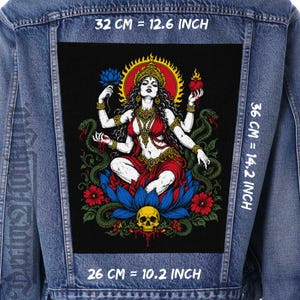 May include: A blue denim jacket featuring a large rectangular back patch with a multi-armed figure sitting on a blue lotus flower, surrounded by snakes, red flowers, and a skull. The patch measures 26 cm by 36 cm, with a 32 cm width.